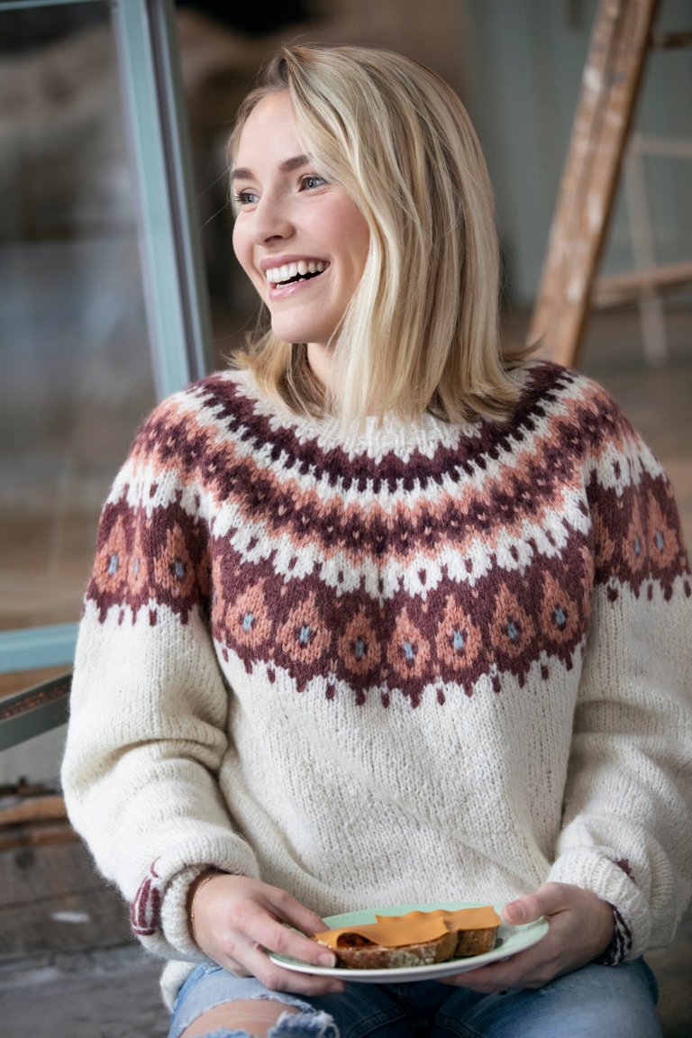 Girl smiling while wearing the Brunost sweater
