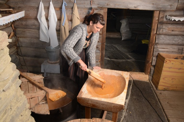 Anne Solbraa illustrating the traditional method for making brown cheese.